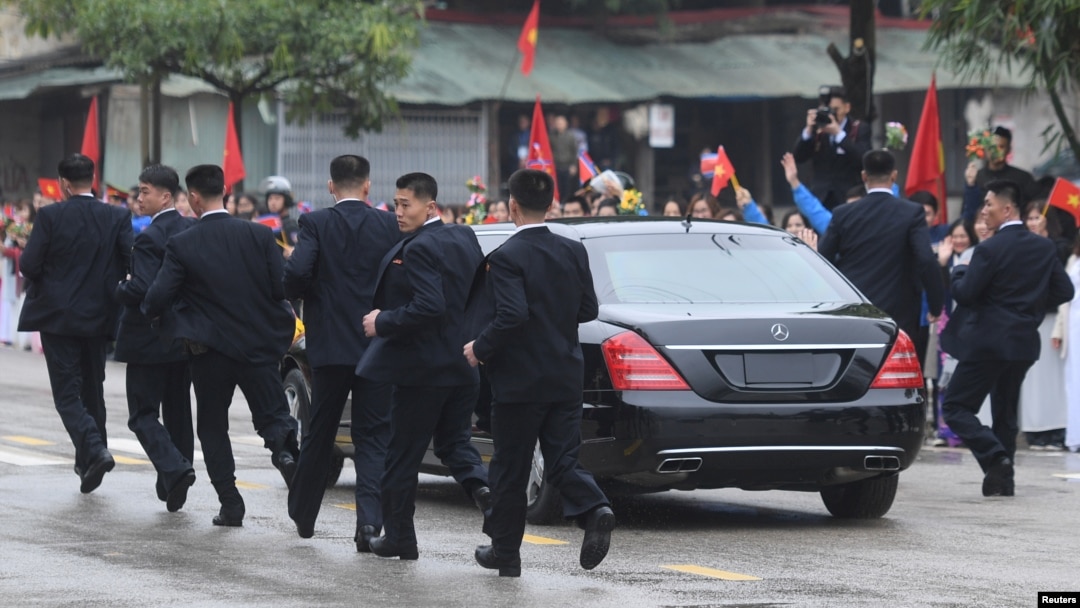 Các vệ sĩ chạy theo chiếc limousine chở lãnh đạo Triều Tiên Kim Jong Un từ ga Đồng Đăng đi Hà Nội ngày 26/2/2019. 