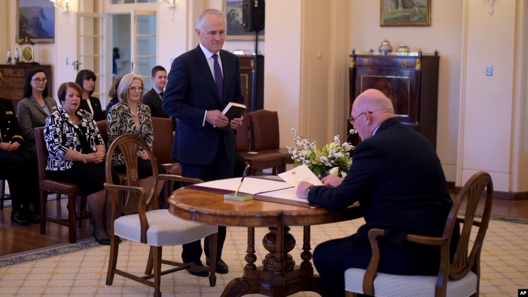 Malcolm Turnbull, center, is sworn in by Australia's Governor-General Sir Peter Cosgrove, right, as prime minister at Government House in Canberra, Tuesday, Sept. 15, 2015.