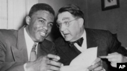 Atlet bisbol AS Jackie Robinson dan presiden tim Brooklyn Dodgers Branch Rickey tahun 1950.