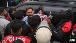Police detain a supporter of former prime minister Imran Khan's Pakistan Tehreek-e-Insaf (PTI) party, at a protest against the alleged skewing in Pakistan's national election, in Lahore, on March 10, 2024.