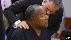 O.J. Simpson escucha a su abogado, Ozzie Fumo, durante la audiencia ante el consejo de libertad condicional en Nevada.