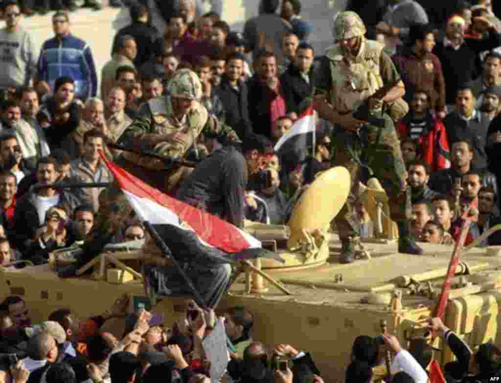 Bleeding Egyptian photographer, Mohammed Omar, is helped by army soldier to receive medical support during clashes between President Hosni Mubarak, supporters and anti-Mubarak protesters in Cairo, Egypt, Wednesday, Feb.2, 2011. Several thousand supporters