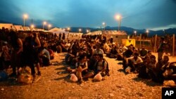 People sit on the ground at a refugee camp in the southern Macedonian town of Gevgelija, Sept. 8, 2015. 