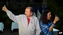 Daniel Ortega, y su esposa y vicepresienta de Nicaragua Rosario Murillo, muestran sus pulgares marcados después de votar en un centro cerca de su casa en Managua, Nicaragua, el 6 de noviembre de 2016. 