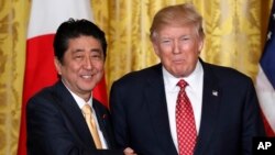 Presiden AS Donald Trump (kanan) dan PM Jepang Shinzo Abe berjabat tangan usai mengadakan konferensi pers bersama di Gedung Putih, Jumat (10/2). 