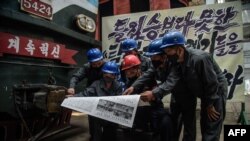 지난 6월 북한 평양 김종태전기기관차공장 노동자들이 노동신문을 읽고 있다.