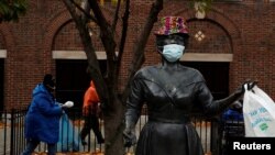 A bronze statue of late singer Ella Fitzgerald is seen wearing a hat and protective face mask, as the global outbreak of the coronavirus disease continues, outside the Metro-North Railroad Station Plaza in Yonkers, New York, Nov. 17, 2020.
