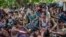 FILE - Rohingya Muslims from Myanmar wait to carry food items from Bangladesh's border toward a no man's land where they set up refugee camps, in Tombru, Bangladesh, Sept. 15, 2017. 
