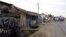 A policeman watches from a distance as residents gather near the bodies of unidentified men killed during gunfire, in the Nyakabiga neighborhood of Burundi's capital Bujumbura, Dec. 12, 2015.