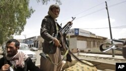 Armed Yemeni tribesmen stand guard in a street in Sanaa, Yemen, May 29, 2011