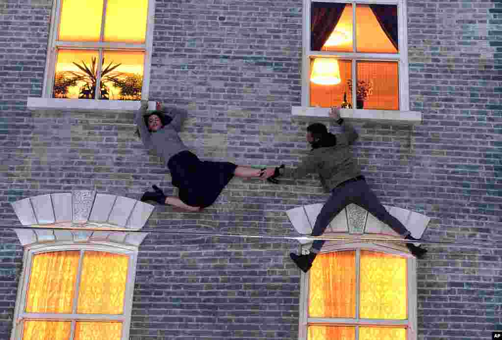 Dua pengunjung bermain dengan ilusi pada sebuah instalasi karya Leandro Erlich di Dalston House, London.