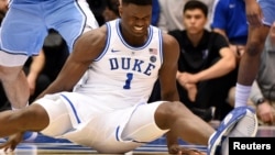 FILE - Duke's Zion Williamson sits on the floor after his shoe split open during the first half of an NCAA college basketball game against North Carolina in Durham, N.C., Feb. 20, 2019.