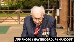 A handout photo taken in April 2020, and released by the Maytrix Group in London on April 14, 2020, shows World War Two (WWII) veteran 99-year-old Captain Tom Moore walking in his garden in Marston Moretaine, north of London, to raise money for Britain's 