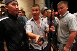 Armed supporters of Kyrgyz former President Almazbek Atambayev guard his house during an operation of state security forces to detain Atambayev, in the village of Koi Tash, Aug. 07, 2019.