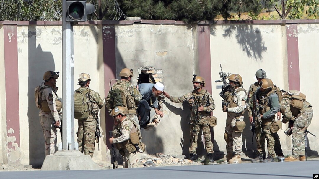 Afghan security personnel rescue a man from the Shamshad TV compound after an attack in Kabul, Nov. 7, 2017.