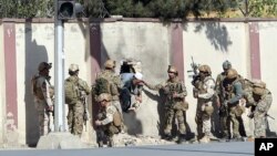 Afghan security personnel rescue a man from the Shamshad TV compound after an attack in Kabul, Nov. 7, 2017.