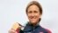  Cyclist Kristin Armstrong of the United States poses with her gold medal, Rio de Janeiro, Brazil, Aug. 10, 2016.