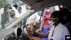 FILE - Rebecca Makyeli, right, spokeswoman for Uganda's new all-female ride-hailing service Diva Taxi, trains new drivers in self-defense skills in Kampala, Uganda, Sept. 28, 2020.