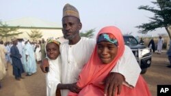 FILE—Parents are reunited with their daughters in Jangabe, Nigeria, March 3, 2021. 