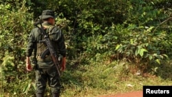 Un guerrillero del Estado Mayor Central (EMC), una facción de las FARC que rechazó el acuerdo de paz de 2016 y continuó la lucha armada, hace guardia en un puesto de control instalado en una carretera en Llanos del Yari, Colombia, el 12 de abril de 2024. 