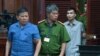 This picture from the Vietnam News Agency taken and released on Nov. 11, 2019 shows Australian citizen Chau Van Kham (L) escorted for trial in Ho Chi Minh City.