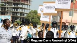 South Sudanese children march alongside a police band in Juba on Monday, June 16, 2014, to mark the Day of the African Child. 