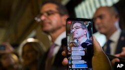 A person makes a live video as appointed Secretary of State Pedro Pierluisi arrives to the Senate, in San Juan, Puerto Rico, Aug. 1, 2019.