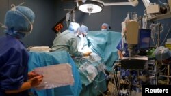 FILE - Medical team perform a heart surgery in an operating room at the Saint-Augustin clinic in Bordeaux, France.