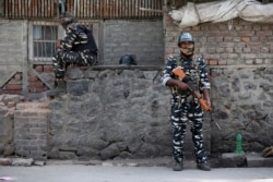 FILE - Indian paramilitary soldiers stand guard outside the main telephone exchange building in Srinagar, Indian-controlled Kashmir, Sept. 5, 2019.