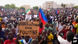 FILE - Nigeriens participate in a march called by supporters of coup leader Gen. Abdourahmane Tchiani in Niamey, Niger, Sunday, July 30, 2023. The French Foreign Ministry says Tuesday, Aug.1, 2023. Poster reads: Down with France, long live Putin."