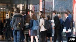 FILE - A group of students enters the building that houses the Russian Mission to the United Nations in New York for a tour, March 26, 2018. Russia is urging about 60,000 of its citizens studying abroad to return home.