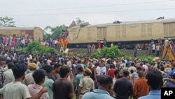 Onlookers watch as rescuers work after a cargo train rammed into Kanchanjunga Express, a passenger train, near New Jalpaiguri station, West Bengal state, India, June 17, 2024. 