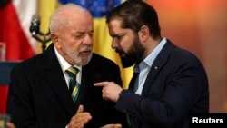 El presidente brasileño Luiz Inacio Lula da Silva y el presidente chileno Gabriel Boric conversan antes de brindar un pronunciamiento en Palacio de La Moneda, en Santiago, el 5 de agosto de 2024.