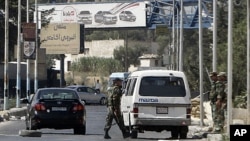 Syrian soldiers man a checkpoint at the entrance of Harasta northeast of the capital Damascus, August 29, 2011