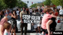 Protesters gather at the scene where George Floyd, an unarmed black man, was pinned down by a police officer kneeling on his neck before later dying in hospital in Minneapolis, Minnesota, May 26, 2020.