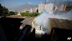 FILE - A Sucre municipality worker fumigates for Aedes aegypti mosquitoes that transmit the Zika virus in the Petare neighborhood of Caracas, Venezuela, Feb. 1, 2016.