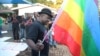 FILE - Chesterfield Samba, director of Gays and Lesbians of Zimbabwe, prepares to hoist the pride flag alongside the Zimbabwean flag during an event in Harare, May, 19, 2012. Zimbabwe's vice president on Feb. 15, 2024, threatened the group for offering university scholarships.