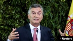 FILE - Argentina's President Mauricio Macri gestures as he gives a speech during a state dinner at the Centro Cultural Kirchner, in Buenos Aires, Argentina, March 25, 2019. 