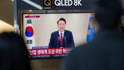 Orang-orang menonton siaran TV yang menampilkan Presiden Korea Selatan Yoon Suk Yeol, di Stasiun Kereta Api Seoul di Seoul, Korea Selatan, 12 Desember 2024. (Foto: AP)