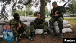 Armed militiamen supporting the self-proclaimed Donetsk People's Republic guard a checkpoint in the eastern Ukrainian city of Donetsk, June 1, 2014.