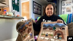 Seraphine Warren poses for a photo in her home in Tooele, Utah, on Sept. 23, 2021, with a rug made by her aunt, Navajo rug weaver Ella Mae Begay.