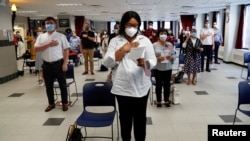 Personas durante una ceremonia de naturalización del USCIS, en Nueva York, EE.UU., el 22 de julio de 2020, mientras continúa el brote de la enfermedad del coronavirus.