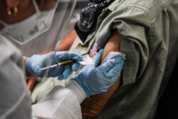Seorang pria menerima suntikan vaksin Covid-19 dalam uji klinis Research Centers of America, di Hollywood, Florida, 13 Agustus 2020.