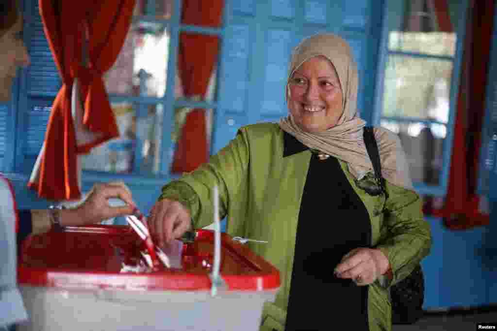  Mpiga kura atumbukiza kura ndani ya sanduku la kura mjini Tunis