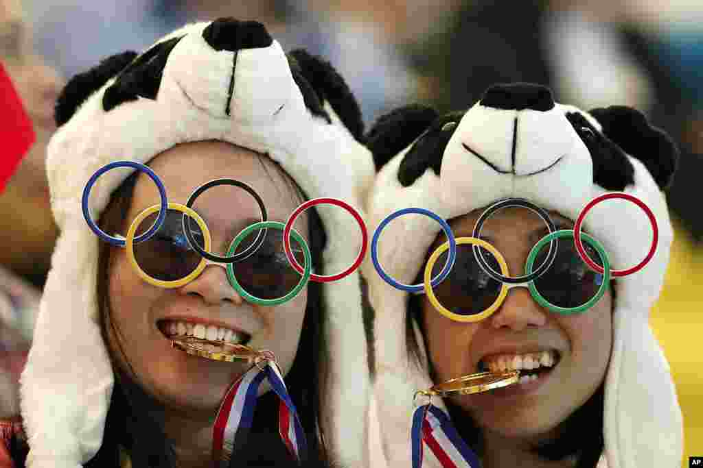 Dos espectadoras chinas posan para la foto durante la competencia de Clavados Sincronizados, en el Centro Acuático de Londres.