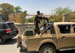 FILE - An Afghan soldier stands in a military vehicle on a street in Kabul, Aug. 15, 2021.