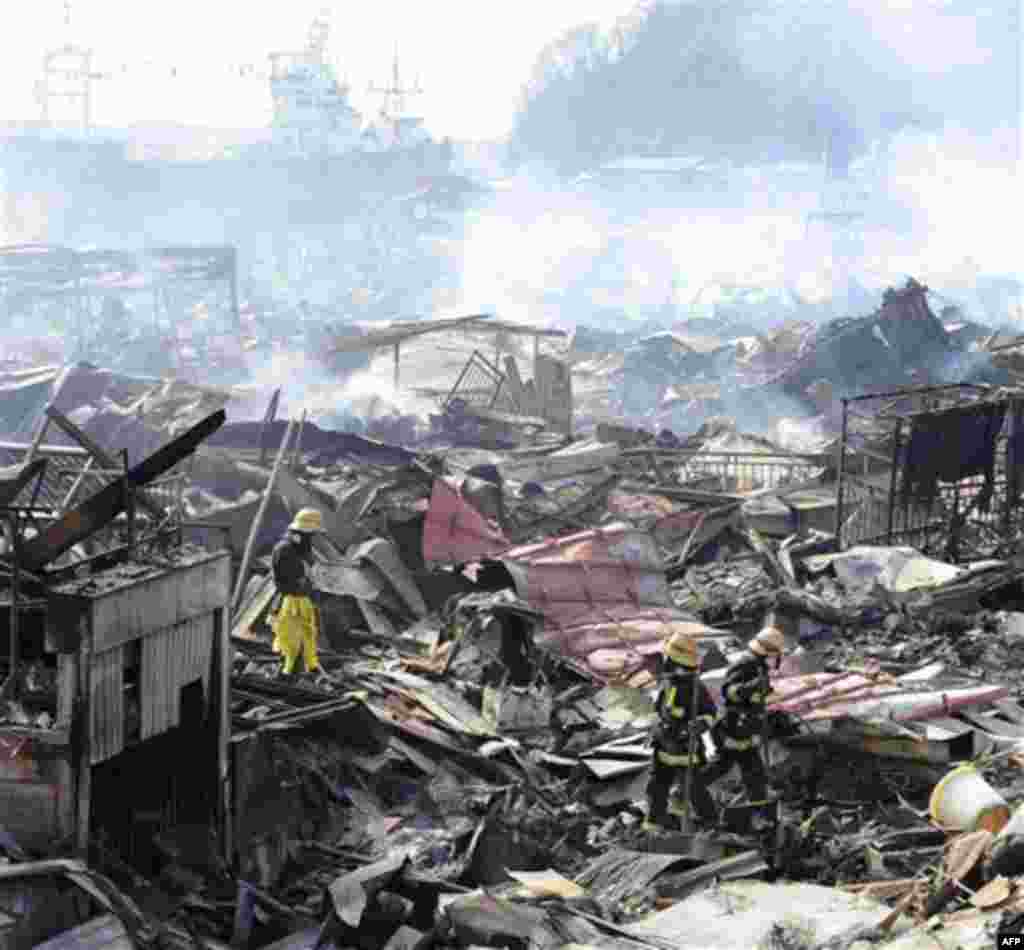 Rescuers conduct search operation amidst smoldering debris in Kesennuma, northern Japan Monday, March 14, 2011 following Friday's massive earthquake and the ensuing tsunami. (AP Photo/Yomiuri Shimbun, Miho Ikeya) JAPAN OUT, MANDATORY CREDIT