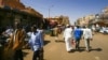 People walk in front of shops at a market in the Sudanese capital, Khartoum, Feb. 21, 2021. Sudan has ratified U.N. conventions against torture and enforced disappearances, after months of delay. 