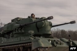 Seorang tentara Ukraina duduk di dalam tank senjata antipesawat Gepard Jerman yang digunakan untuk menargetkan drone yang diluncurkan Rusia di pinggiran Kyiv, pada 30 November 2023. (Foto: AFP)