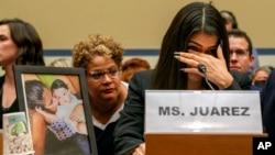FILE - Yazmin Juárez reacts as a photos of her daughter, Mariee, 1, who died after her released from detention by US Immigration and Customs Enforcement, is placed nearby at a House Oversight subcommittee hearing, Capitol Hill, Washington, July 10, 2019.
